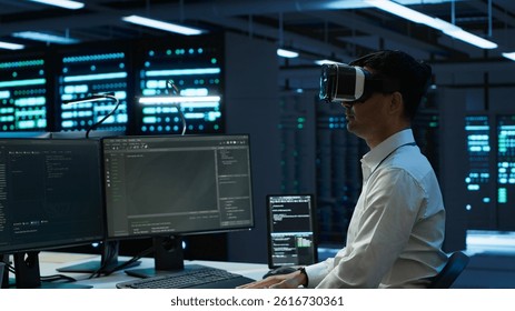 Admin in data center using virtual reality tech to ensure system can handle networking tasks. Server room worker wearing VR headset to track network traffic with PC, making improvements, camera A