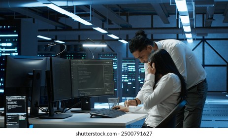 Admin in data center working with colleague to maintaining accurate documentation of equipment, generating reports. Server hub teamworking coworkers doing disaster recovery planning, camera A