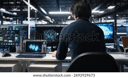 Admin entering data center office, reviews AI diagnostics on computer. IT expert starting work at server farm desk, optimizing artificial intelligence systems configuration, camera A