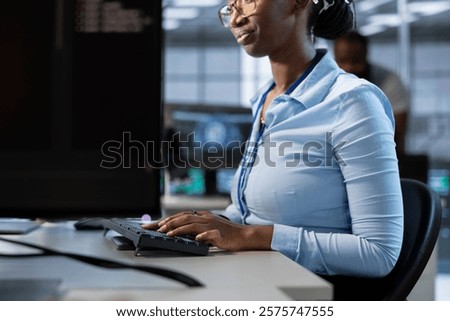 Admin implementing cybersecurity measures to protect data center assets and information. Employee monitoring and analyzing server room metrics to enhance operational effectiveness