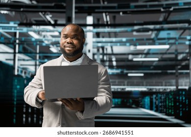 Admin in server hub checking recovery plan on laptop, monitoring data center energy consumption. Data center worker making sure sensors are functioning optimally, doing routine disk checks