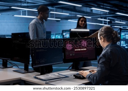 Admin in server hub trying to protect hardware from hacker attack stealing sensitive information. Data center employee struggling to erase virus after seeing security breach alert on monitor