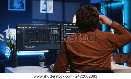 Admin using javascript coding language to fortify security and safeguard consumer data, remotely working for IT company. Software developer upgrading binary code scripts on computer terminal, camera A