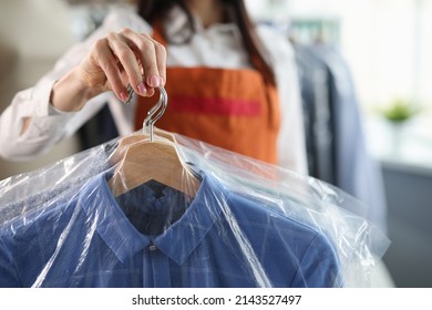 Administrator At Dry Cleaners Keeps Clean Clothes On Hangers In Bag