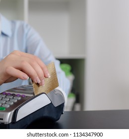 Administrator at gym using payment terminal for paying by credit card