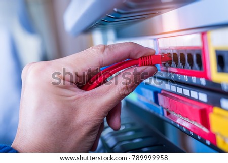 administrator holding network cables connected to servers