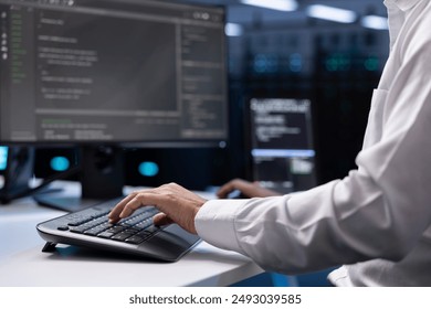 IT administrator working on PC in hardware room housing server rackmounts, storage devices and networking units providing vast amounts of computing resources, doing equipment maintenance, close up - Powered by Shutterstock