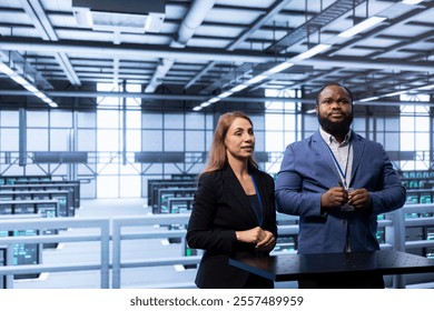 Admins in data center tracking network traffic and activity using augmented reality technology and installing software updates. Coworkers performing database backups using AR tech visualization