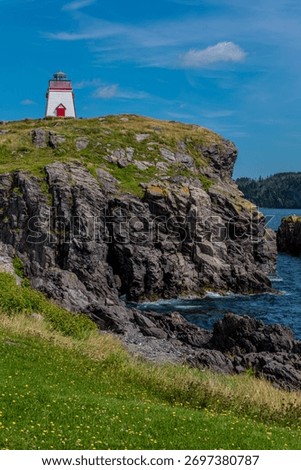 Admirals Point Lighthouse above the cliffs on the coastline near Trinity, Newfoundland
