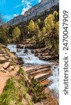 Admiring the majesty of the Arazas River waterfall in the splendid Ordesa and Monte Perdido National Park, a natural paradise in the Pyrenees of Huesca, Aragon, where the imposing peaks