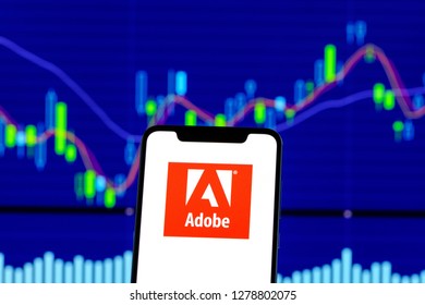 Adobe Logo Is Seen On An Android Mobile Phone Over Stock Chart