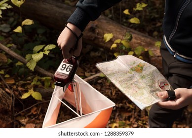 Adolescent in forest checking to a control point in Orienteering competition. Selective focus  - Shutterstock ID 1288359379