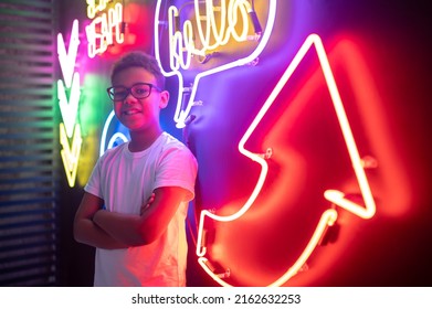 Adolescent Standing Alone By A Wall With Neon Signs