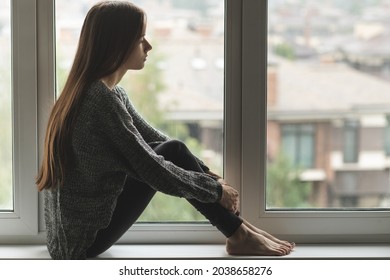 adolescent trouble, sad depressed young woman on the window,unhappy teenager thinks about negative things, problems, suffers - Shutterstock ID 2038658276
