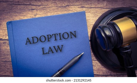 Adoption Law Book And Gavel On Wooden Table.