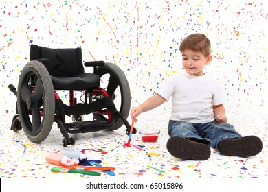 Adorable 2 Year Old Child With Wheelchair Painting On Floor.