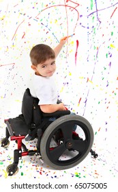 Adorable 2 Year Old Child With Wheelchair Painting On Floor.