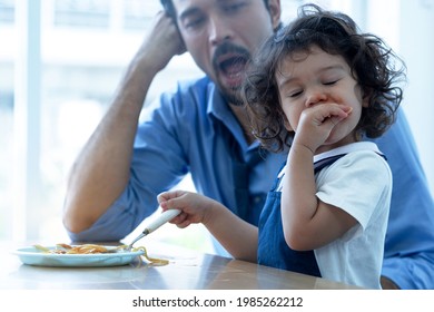 Adorable 2 Years Old Girl Eating Spaghetti Pasta Enjoyment With Their Hands, And Father Sitting Nearby 