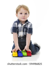 An Adorable 2-year-old Looking Up From His 4 Toy Vehicle Lineup.  On A White Background.