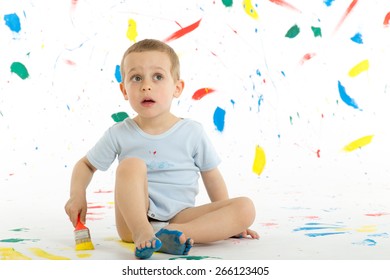 Adorable 3 Year Old Boy Child Creatively Stains On The Wall, Floor With Colourful Paint. Mess Of Paint On Wall, Floor And Everywhere.