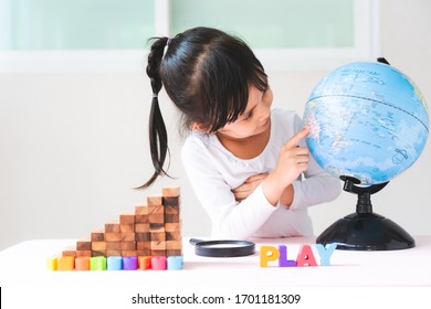 Adorable 4 Years Old Asian Little Girl Is Learning The Bilingual Globe Model Contain English And Thai Language, Concept Of Save The World And Learn Through Play Activity For Kid Eduation At Home.