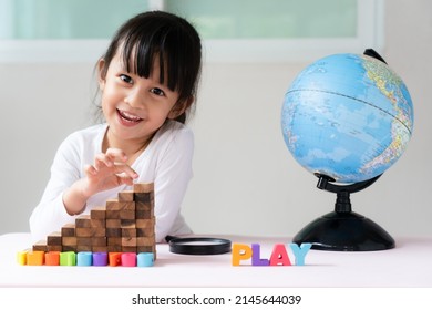 Adorable 4 Years Old Asian Little Girl Is Learning The Bilingual Globe Model Contain English And Thai Language, Concept Of Save The World And Learn Through Play Activity For Kid Education At Home.