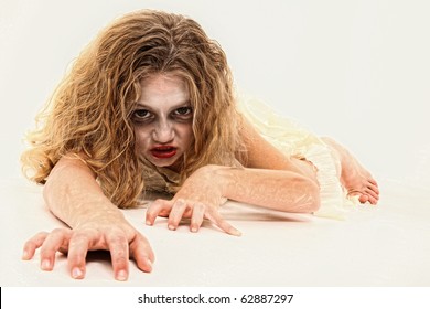 Adorable 7 year old girl in Zombie costume over white background.