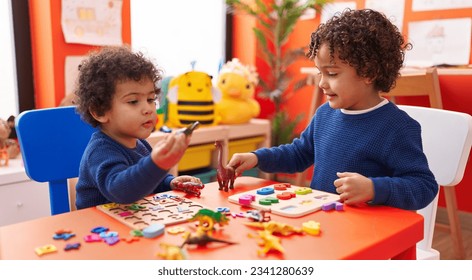 Adorable african american boys playing with maths puzzle game and dinosaur toy at kindergarten - Powered by Shutterstock