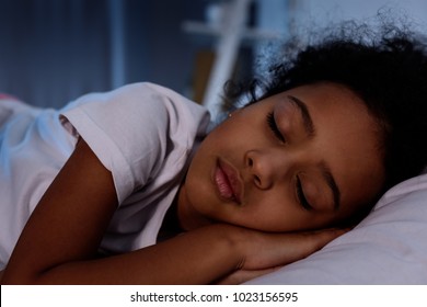 Adorable African American Kid Sleeping In Bed At Home