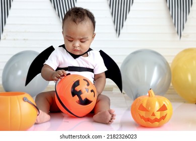 Adorable African Baby Kid Dressing Up In Vampire Fancy Halloween Costume With Black Bat Wings, Cheerful Little Cute Child Go To Party, Playing Trick Or Treat, Happy Halloween Celebration.