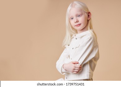 adorable albino girl 7-9 years old posing at camera isolated. shy little caucasian child with unusual natural blonde hair and white skin born with albinism