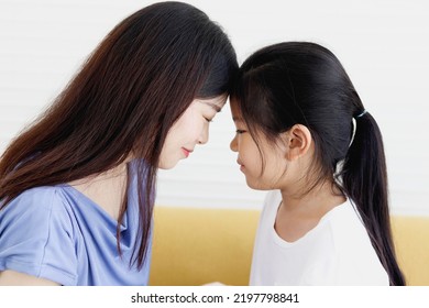 Adorable Asia Happy Family, Cute Little Girl And Her Mother Touching Their Foreheads, Smiling And Looking At Each Other, Warm Love In Family, Happy Mother Day, Kid Have Special Time With Mom.