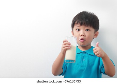 Bé trai châu Á đáng yêu uống sữa với bộ ria mép sữa