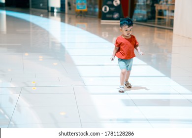 Adorable Asian Boy Running Happily Inside A Mall 