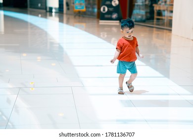 Adorable Asian Boy Running Happily Inside A Mall 