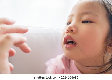 Adorable Asian Girl Kid Getting Swab Test At Home By Her Parent. Rapid Self Test For Covid-19, Antigen Test Kit, Quick Check Before School. New Normal Routine For Kid. Selective Focused.