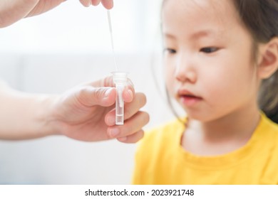 Adorable Asian Girl Kid Pay Attention With Swab Test Process By Her Parent. Rapid Self Test For Covid-19, Antigen Test Kit, Quick Check Before School. New Normal Routine For Kid. Selective Focused.