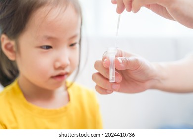 Adorable Asian Girl Kid Pay Attention With Swab Test Process By Her Parent. Rapid Self Test For Covid-19, Antigen Test Kit, Quick Check Before School. New Normal Routine For Kid. Selective Focused.