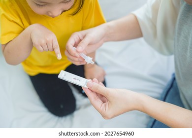 Adorable Asian Girl Kid Pay Attention With Swab Test Process By Her Parent. Rapid Self Test For Covid-19, Antigen Test Kit, Quick Check Before School. New Normal Routine For Kid. Selective Focused.