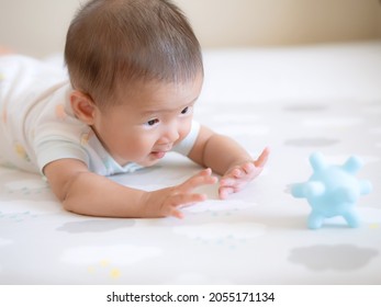 Adorable Asian Girl Try To Crawl To Touch The Toy On  Bed For Tummy Time Or Playtime Of Baby Cute 