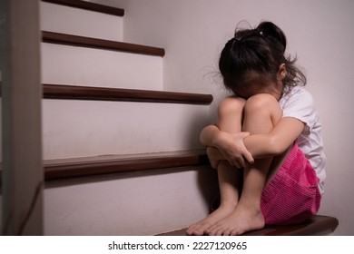 Adorable asian girl who expresses her sadness emotion on house stair alone shows concept of depression, emotional pain and unhappiness of child which might due to abusement from family and school. - Powered by Shutterstock