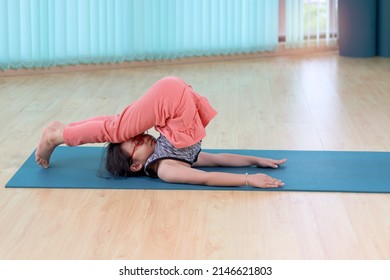 Adorable Asian Little Girl Doing Yoga Exercise At Indoor Studio Together, Sporty Kid Practicing Yoga Standing Together And Doing Flexibility Pose, Working Out And Exercising For Taking Care Of Body