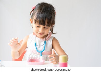 Adorable Asian Little Girl Playing Like She Is The Dentist At Home, Concept Of Learning By Playing For Kid Development.