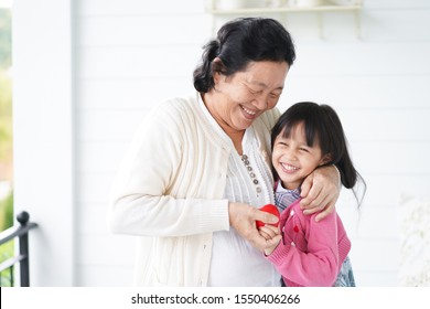 Adorable asian little girl is playing and hugging her grandmother with fully happiness moment, concept of love and bonding of multi generation in asian family lifestyle. - Powered by Shutterstock