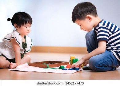 Adorable Asian Montessori School Kids Engaged Wooden Bead Thread Activity, Little Girl Observing While The Kindergarten Boy Teach How To Play. Montessori Classroom, Early Education, Child Development.