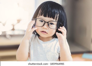 Adorable attraktive Cute-asiatische kleine Mädchen mit Brille Business Intelligent Kind Lernen zu Hause Bildung glücklich fröhlichen Spaß Lifestyle Blick auf Kamera-Gedanken Ideen 