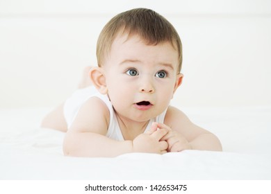 Adorable Baby Boy Lying On The Bed And Trying To Talk