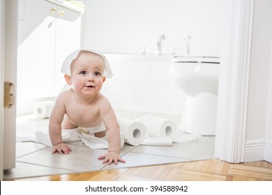 An Adorable Baby Boy Playing With Toilet Paper