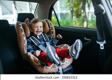 Adorable baby boy in safety car seat. 