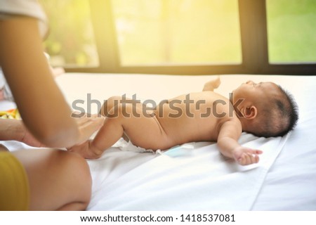 Adorable baby boy in white bedroom. Newborn child relaxing in bed. Textile and bedding for kids. Family morning at home. Portrait of New born kid